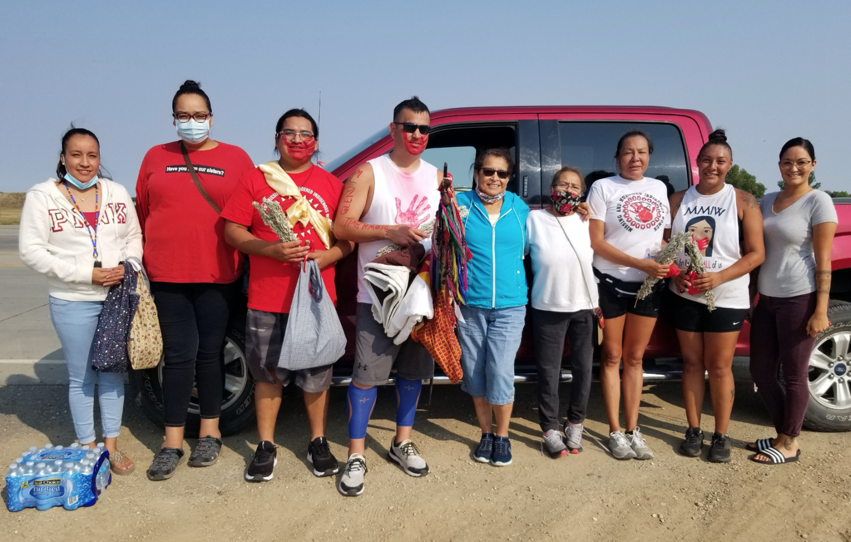 Ethan LaDeaux and Willi Bessette, third and fourth from left, stand with a number of runners on the Rosebud Sioux Reservation during their run across America last summer.